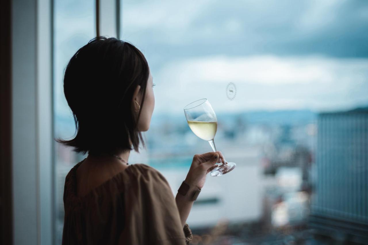 Sheraton Grand Hiroshima Hotel Exterior photo A woman drinking wine